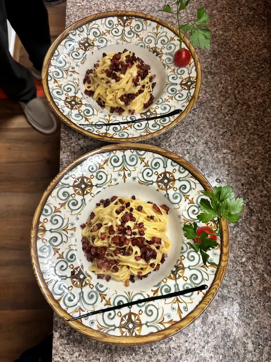 Zwei Teller Carbonara auf bunt bemalten Keramiktellern